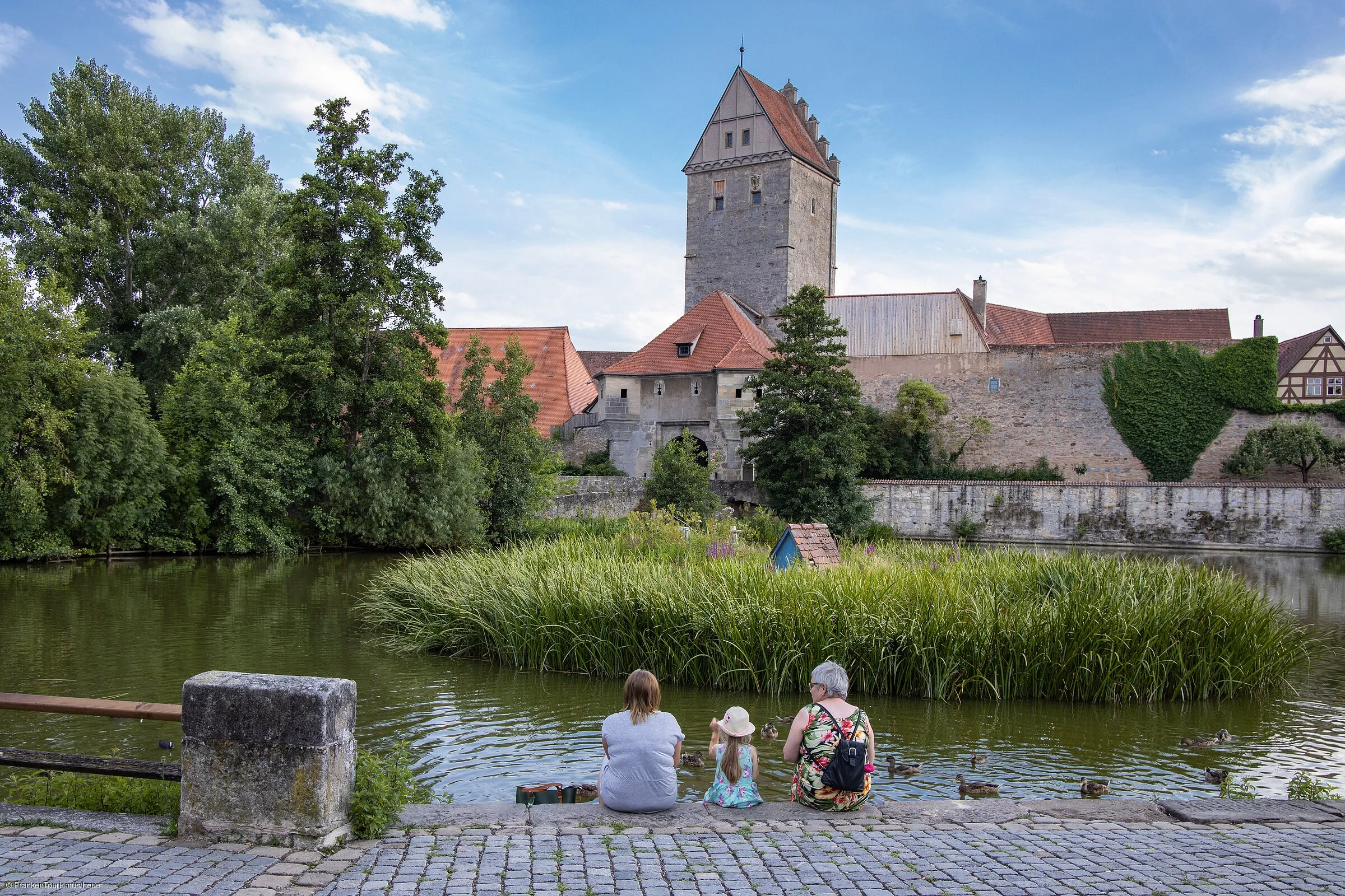 Familie am Rothenburger Weiher mit Blick aufs Rothenburger Tor mit Altstadt-Mauer