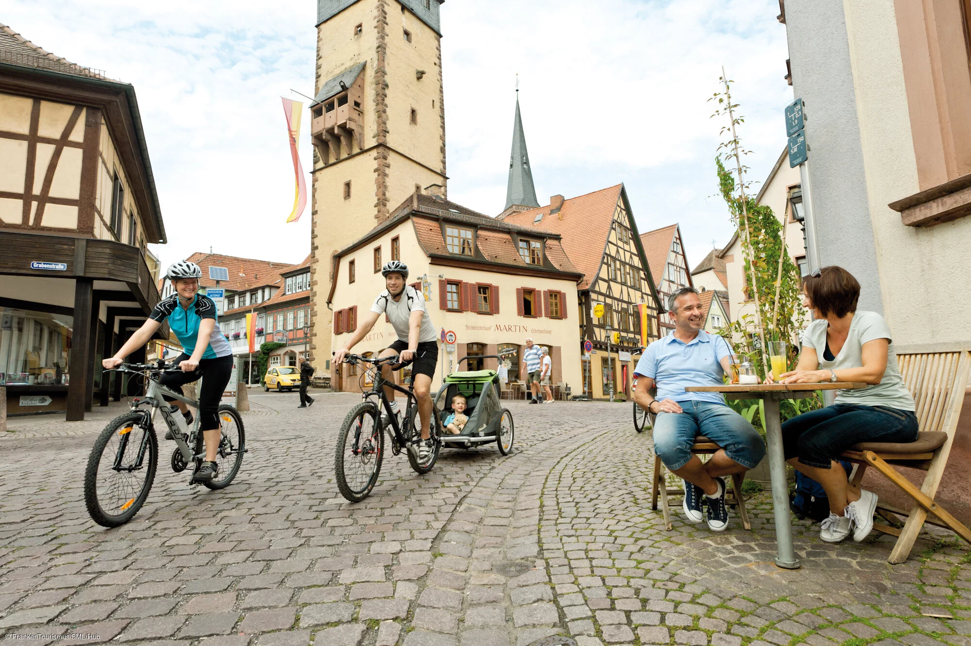 Radfahrer in der Lohrer Altstadt mit Blick auf den Bayersturm