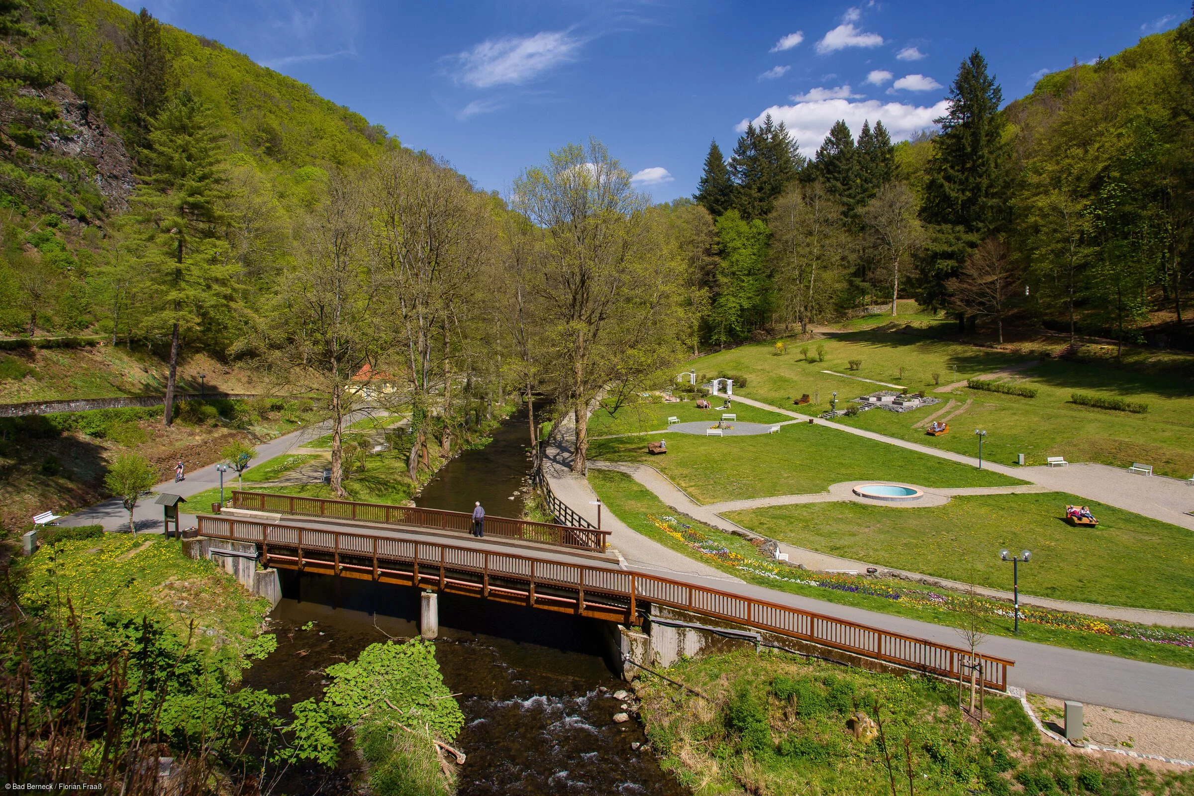 Ein weitläufiger Park im Sommer, mit grünen Wiesen, Bäumen und breiten, geräumigen Wegen