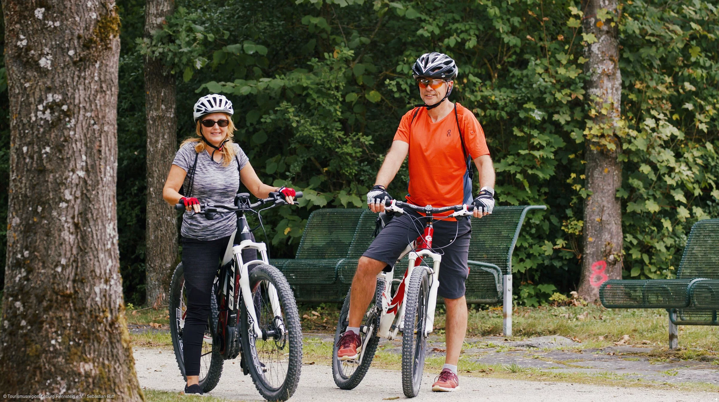 Zwei Radler stehen auf einem Radweg im Wald