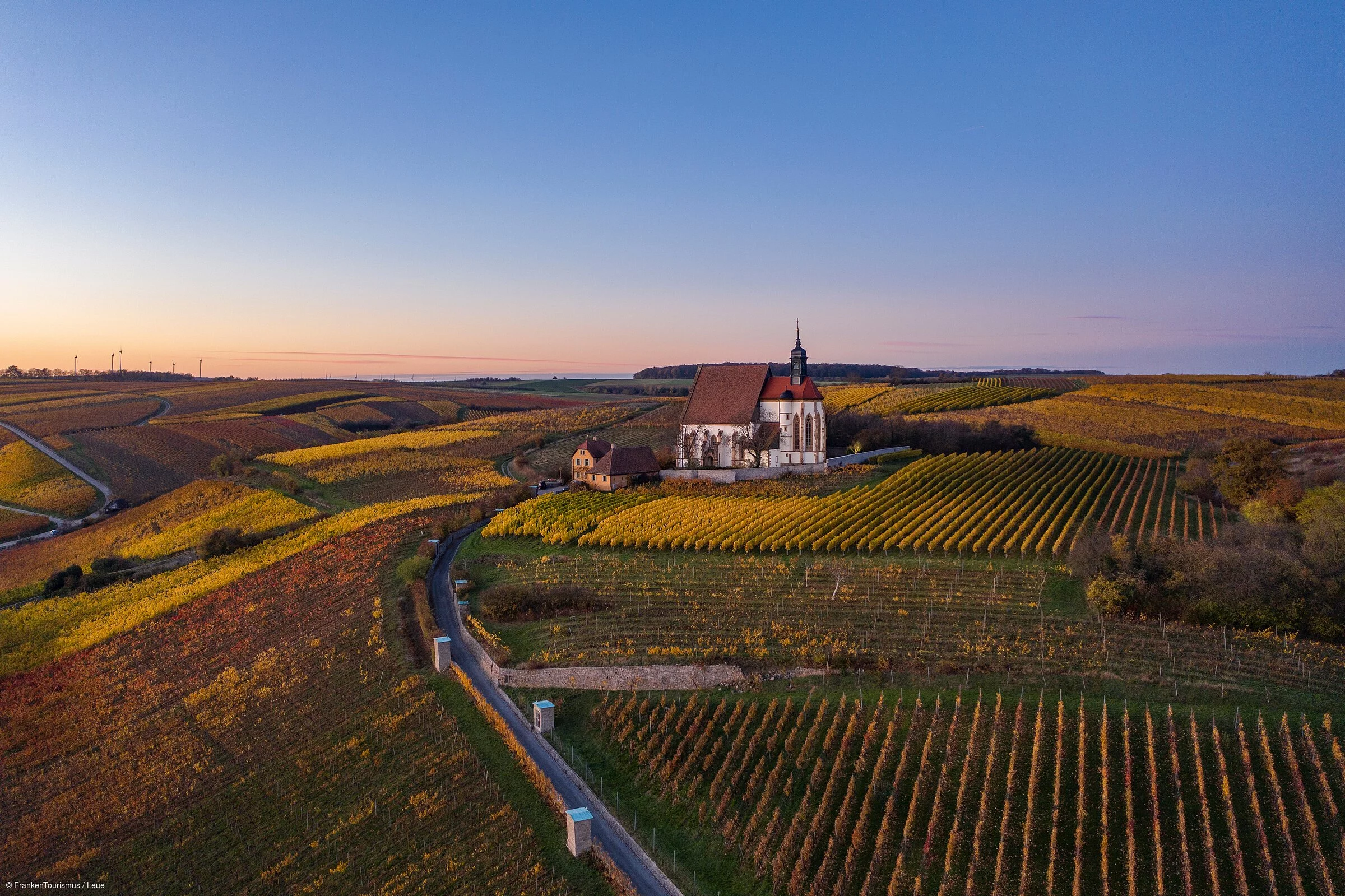 Eine einsame Wallfahrtskirche inmitten von herbstlich bunten Weinbergen