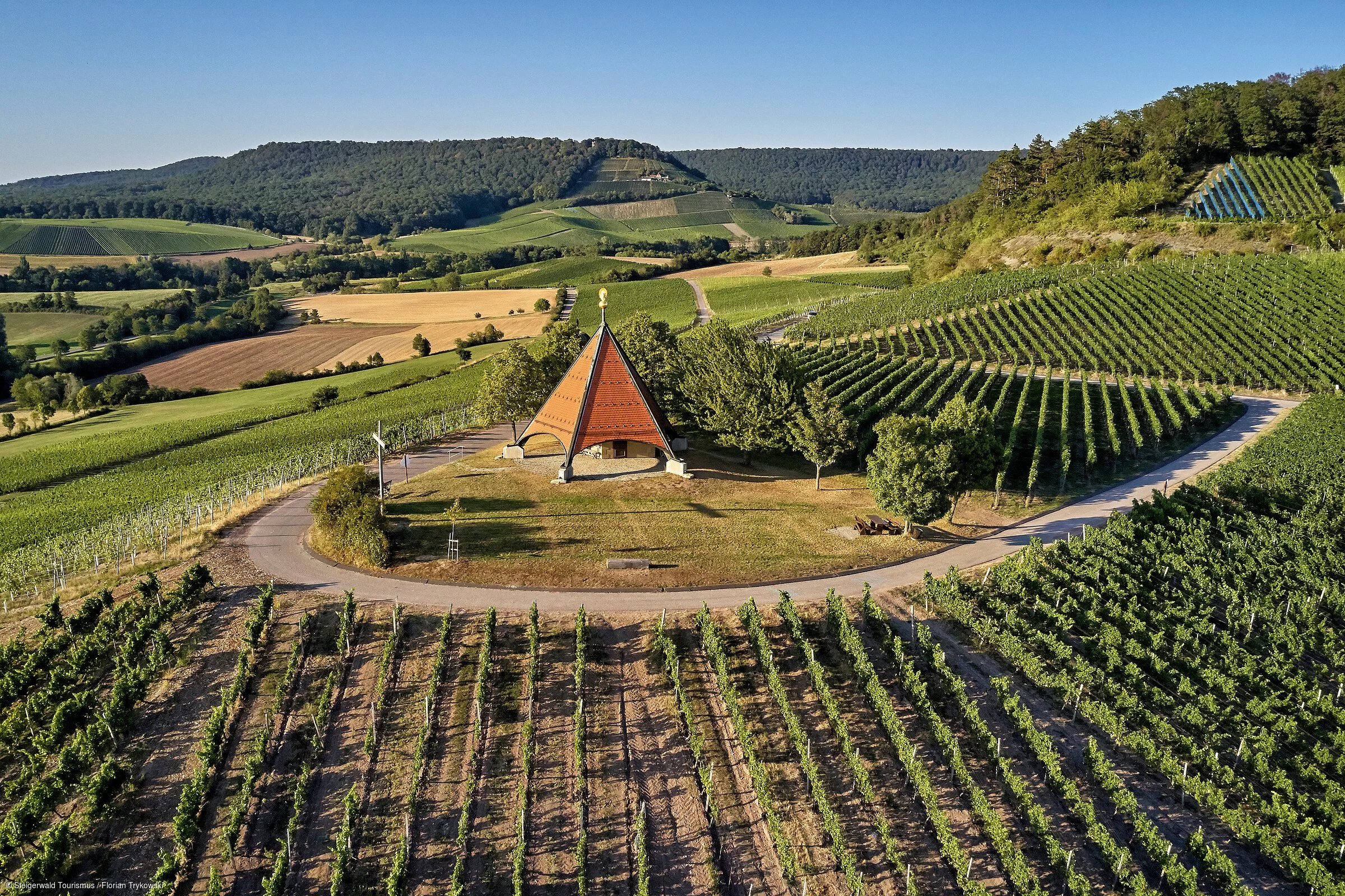 Ein moderne Kapelle auf einem Hügel inmitten grüner Weinberge