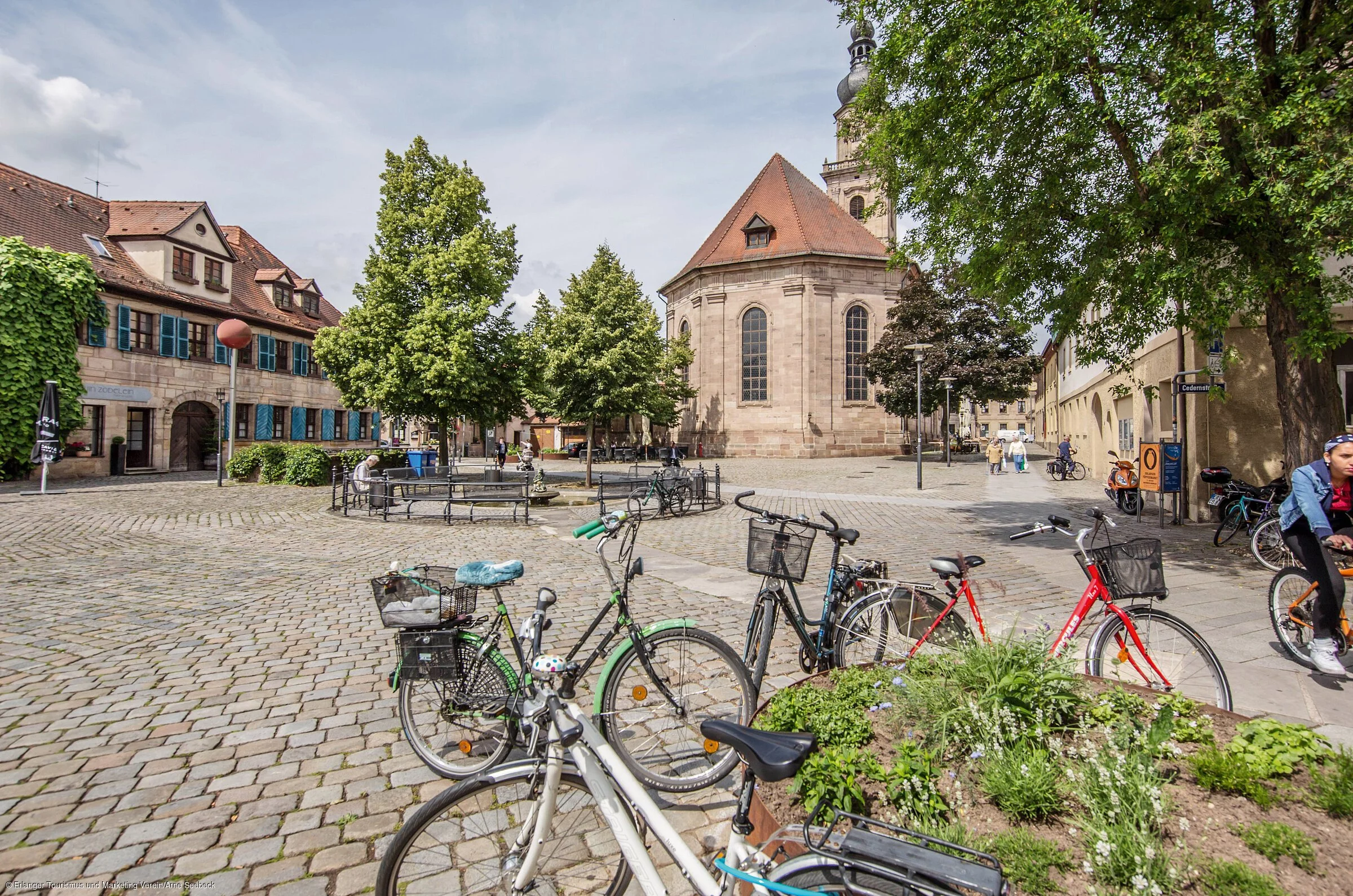 Ein frühlingshafter Stadtplatz mit Sandsteingebäuden, unter anderem eine Kirche